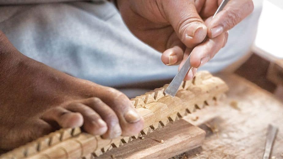 Use a chisel and a carving knife to tease out the fine details of the face and nature elements on the hiking stick