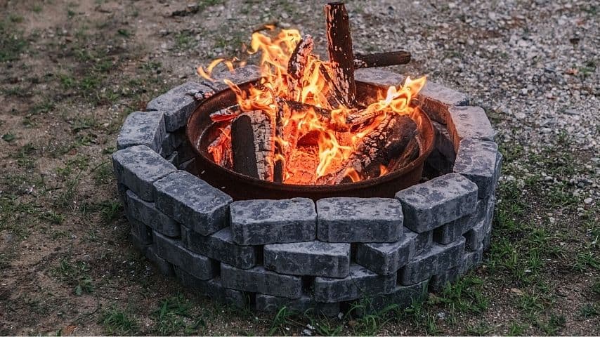 For stone fire pits, taking out a brick from the bottom is enough to allow airflow to the flames